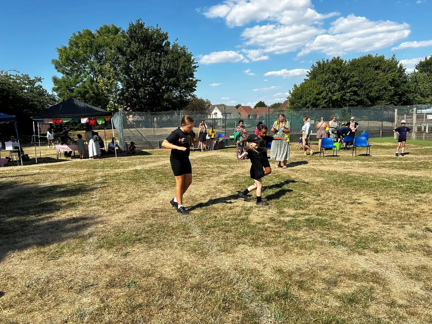 MF Dance instructor supporting a young dancer at a community event